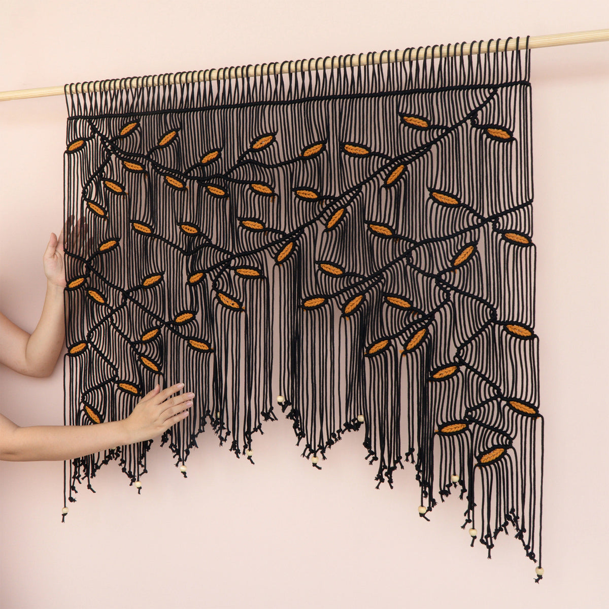 Contemporary bohemian wall hanging crafted from durable cotton cord, combining dark black and sunny mustard colorways.