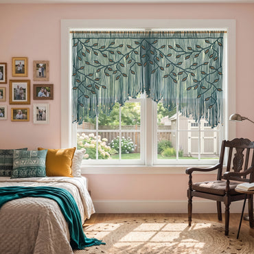 A teal and brown embroidered window valance with fringe, styled in a bedroom setting with a bed, wooden chair, and soft pink walls.
