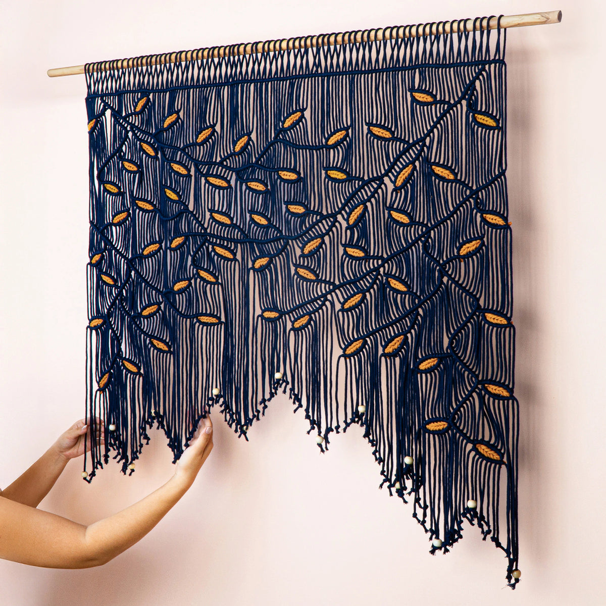 Large bohemian macrame tapestry highlighting organic geometry, flowing vines, and rich botanical leaf patterns.