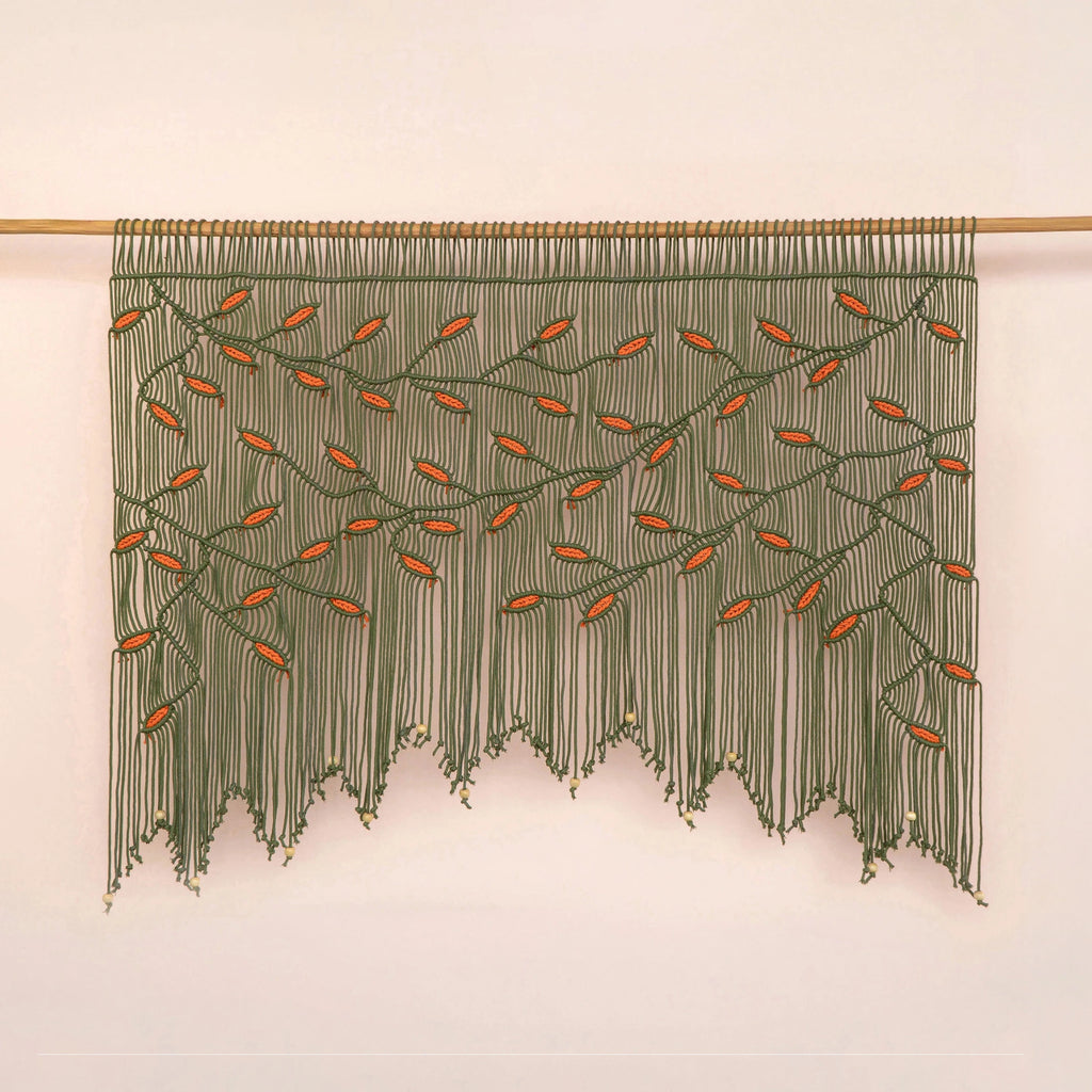 Handcrafted olive green macrame wall hanging featuring an intricate botanical canopy of deep green vines and vibrant orange leaves.