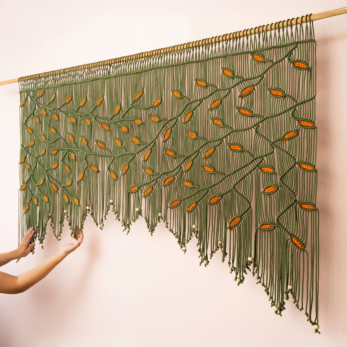 Modern boho olive green macrame tapestry designed with warm earth tones, ideal for living room focal walls and statement interior styling.