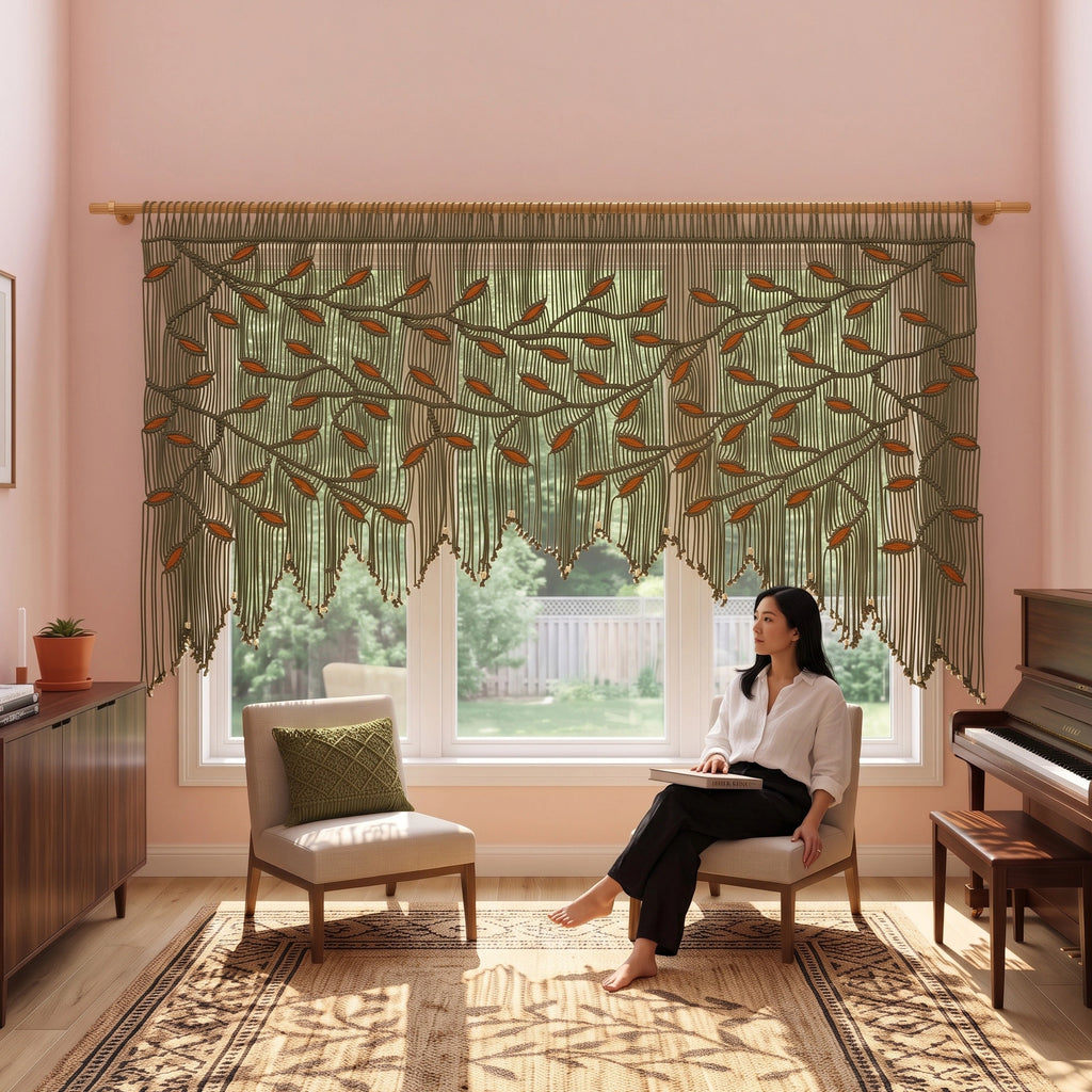 A woman stands in a sunlit kitchen wearing a cream linen outfit, with a large olive green embroidered curtain featuring leafy vine patterns hanging over a window behind her.
