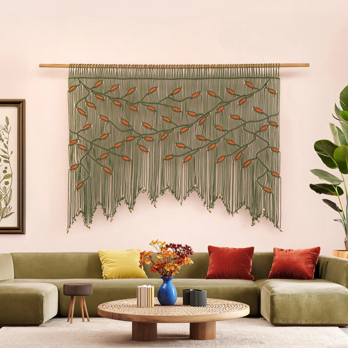 Detailed close-up of a rich olive green macrame wall hanging showing precise knotwork and contrasting vibrant orange botanical leaf motifs.