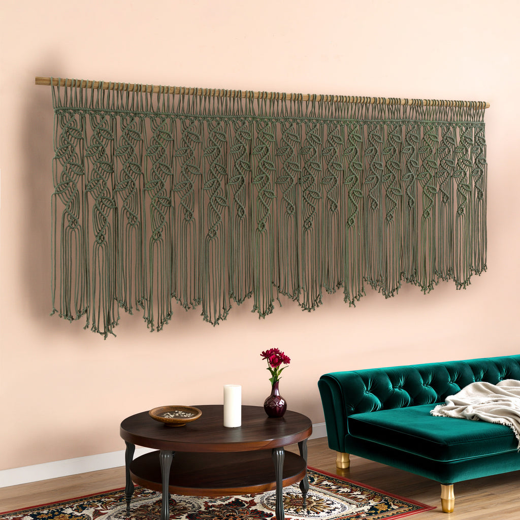 Decorative macrame wall hanging above a living room table with a green sofa.